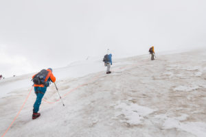 Climber on the way to the Bishorn summit, roped on during a blizzard and heavy fog over the glacier Climber on the way to the Bishorn summit, roped on during a blizzard and heavy fog over the glacier